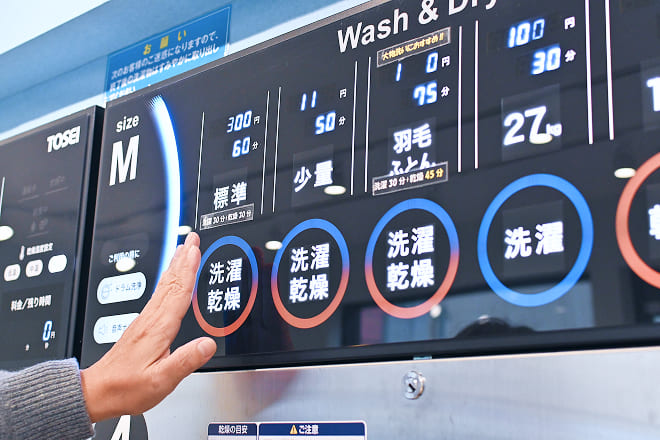 洗濯乾燥ボタンを押す様子